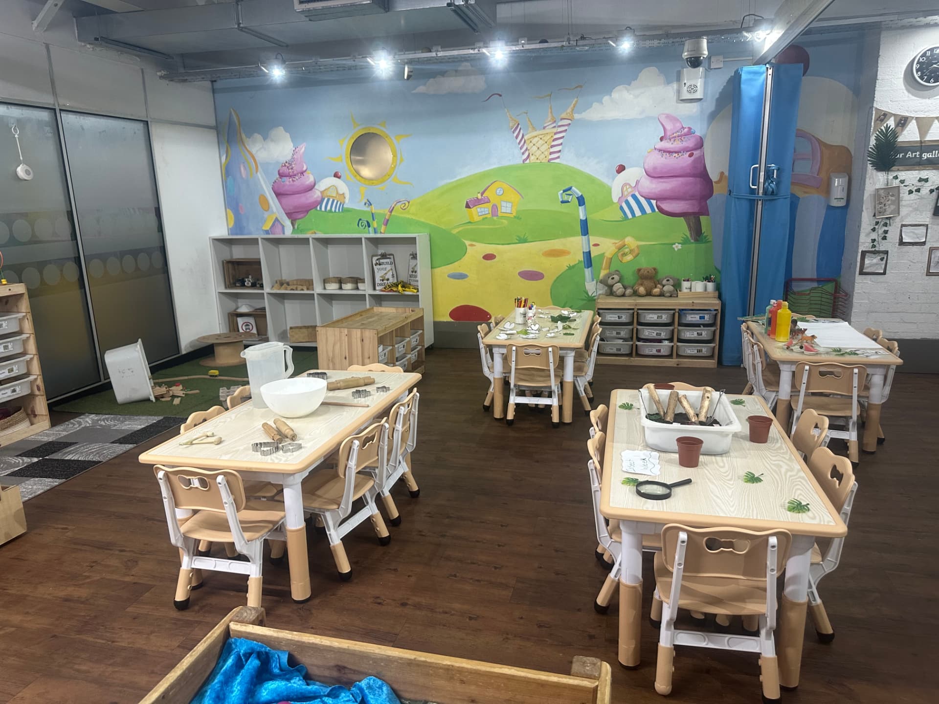 Ladybirds pre-school room at Teenie Weenies nursery with activity tables, mural and art gallery display