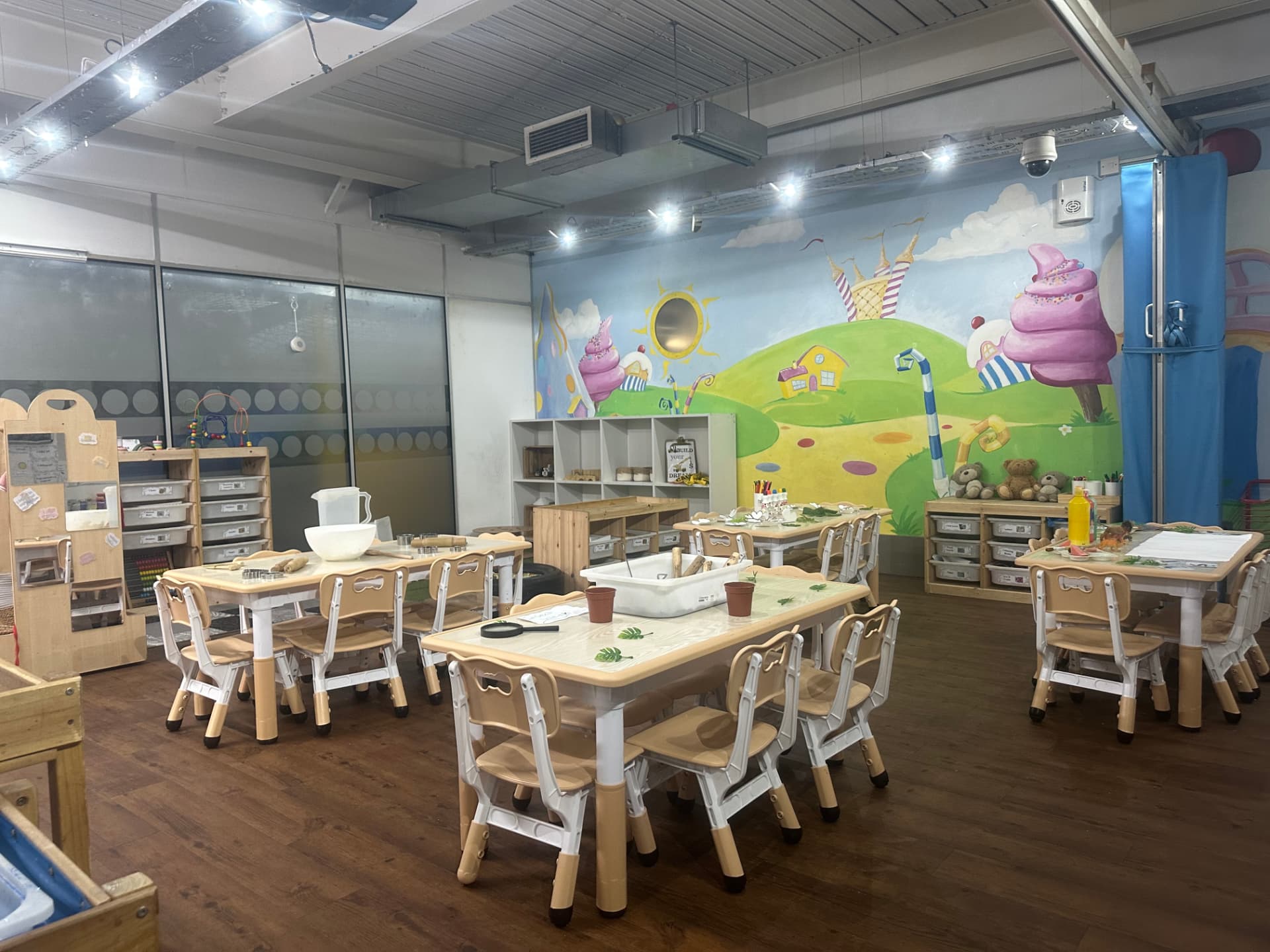 Nursery classroom with group tables and the colourful ice-cream mural at Teenie Weenies